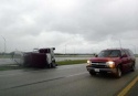 A car drives past an 18-wheel semi truck that jack knifed on interstate 75 after hurricane Charley hit in Port Charlotte, Florida, August 13, 2004. Hurricane Charley slammed Florida\'s west coast with winds of 145 mph (233 kph) on Friday, striking farther south than expected and ripping apart mobile homes, snapping cement columns and shearing off roofs in unprepared seaside towns. REUTERS/Marc Serota 