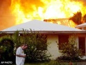 Fri., Aug. 13: A renter bows his head as a fire from a home next door approaches his Fort Myers Beach, Fla., apartment. Witnesses said they heard explosions but were unsure what caused the fire